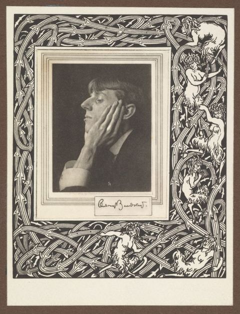 Photogravure. A clean shaven man with a prominent, curving nose faces our left in profile against a dark background. He rests his chin in his hands, and one long-fingered hand lies up along his cheek. The portrait is set in a printed border of interwoven, thorny vines and several creatures with women’s heads and torsos and goats’ legs.